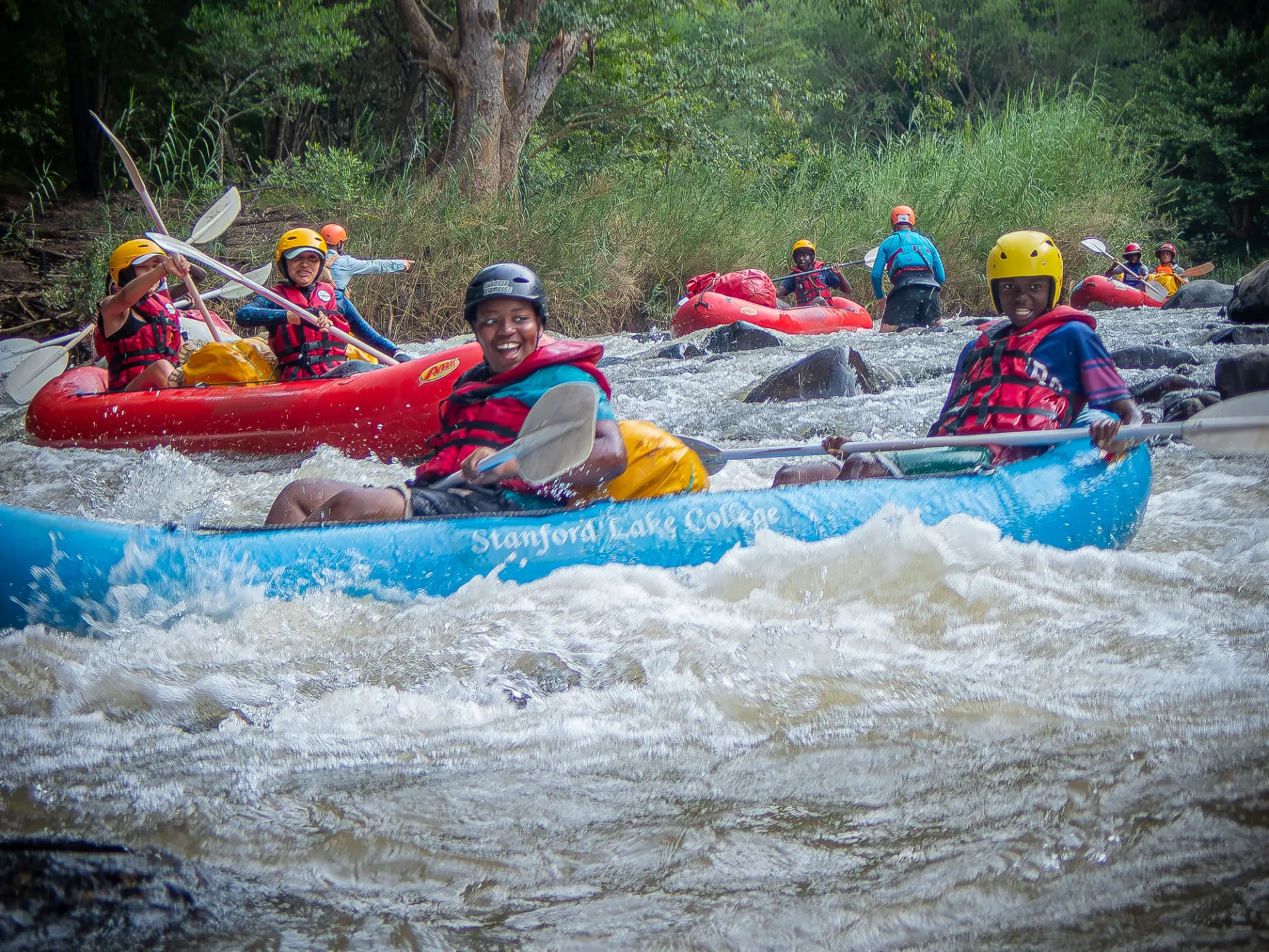 Two paddlers navigating white water in an inflatable canoe