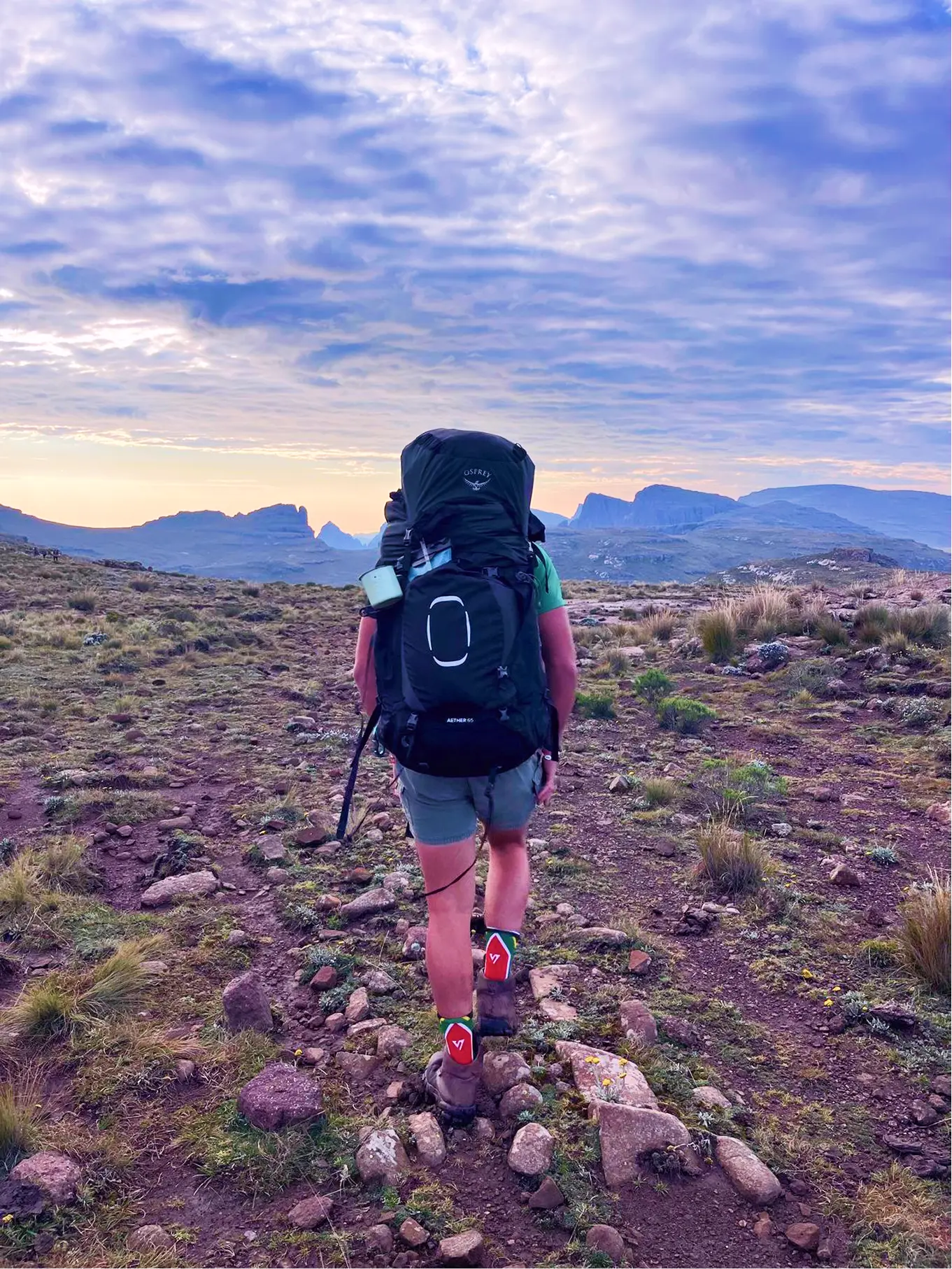 Hiker with a large trekking pack on a rocky mountain path