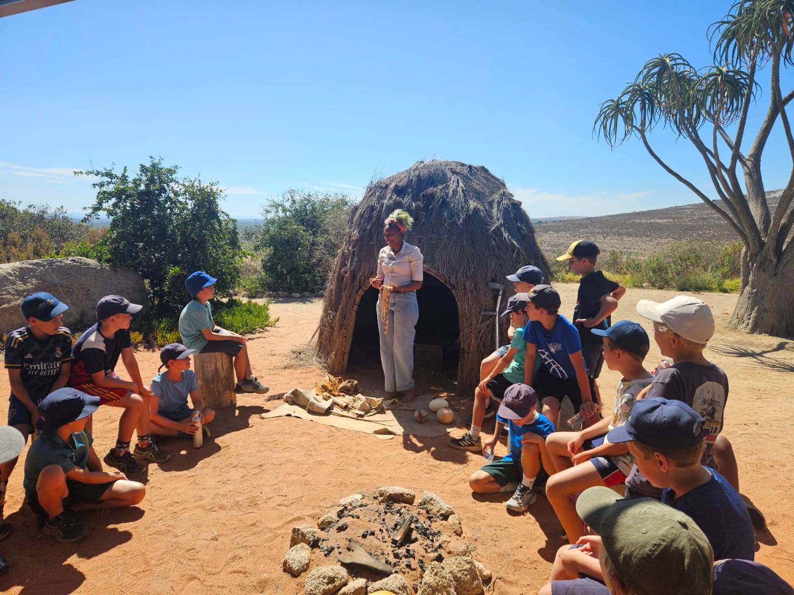 Facilitator leading a circle of children in an outdoor learning session